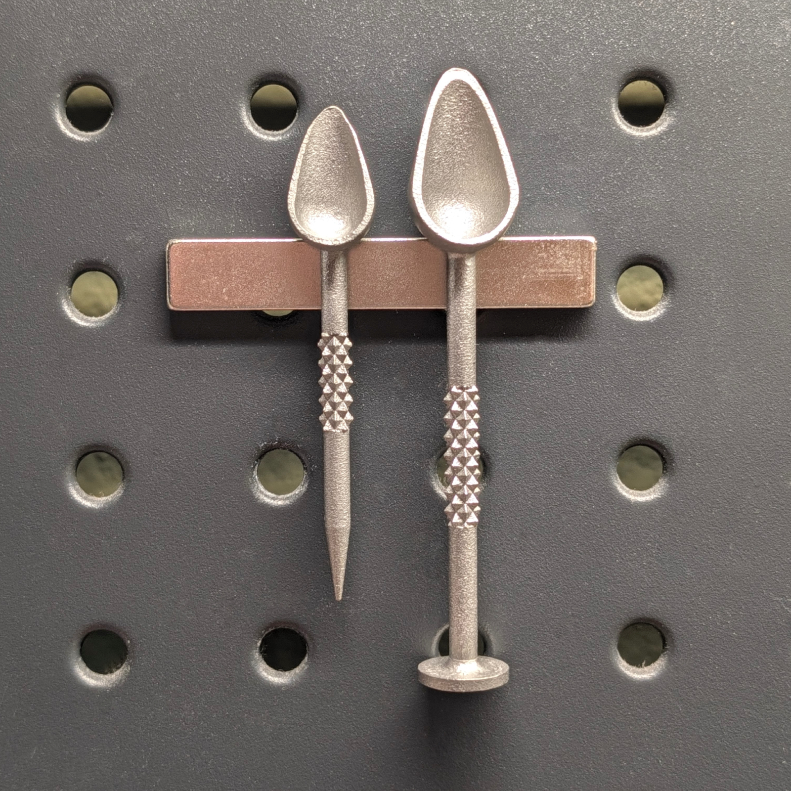 Two 17-4ph scoop tools magnetically attached to a pegboard