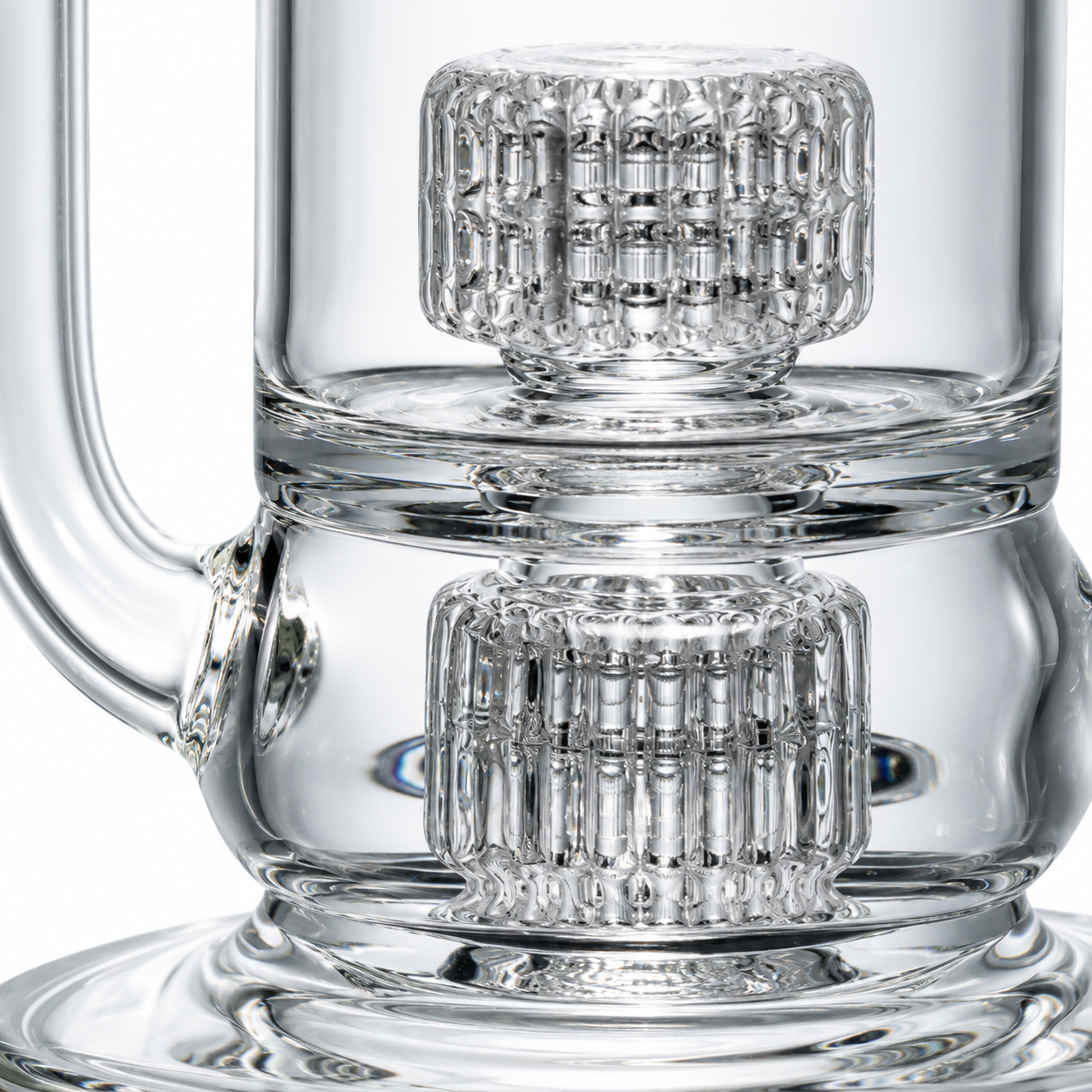 A close-up view of a clear glass matrix perc, highlighting the clean flame-polished cuts, smooth finish, and detailed glasswork inside the waterpipe.