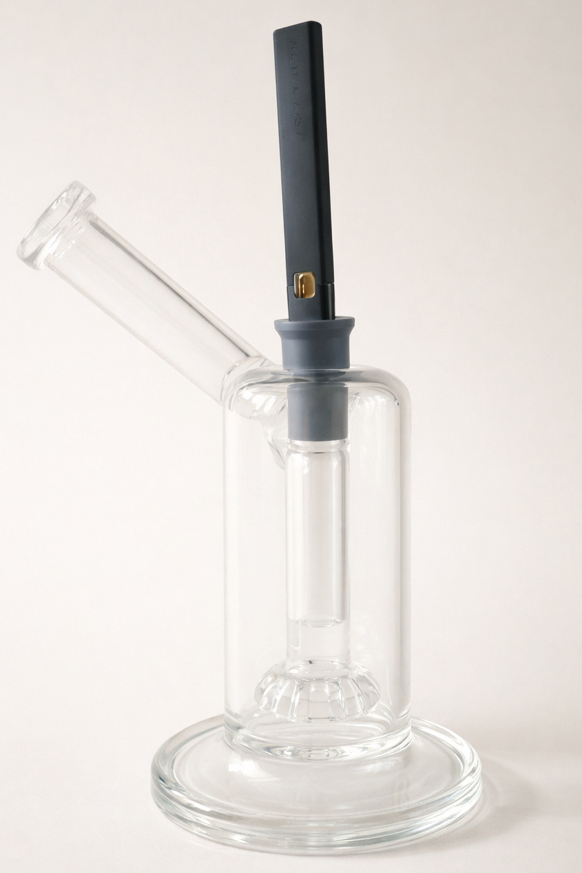 A silicone Nearly Universal Waterpipe Adapter fitted over a vaporizer mouthpiece and connected to a glass water piece. This image shows how a flexible universal-style adapter can bridge a vaporizer to glass when a rigid device-specific waterpipe adapter is not available.